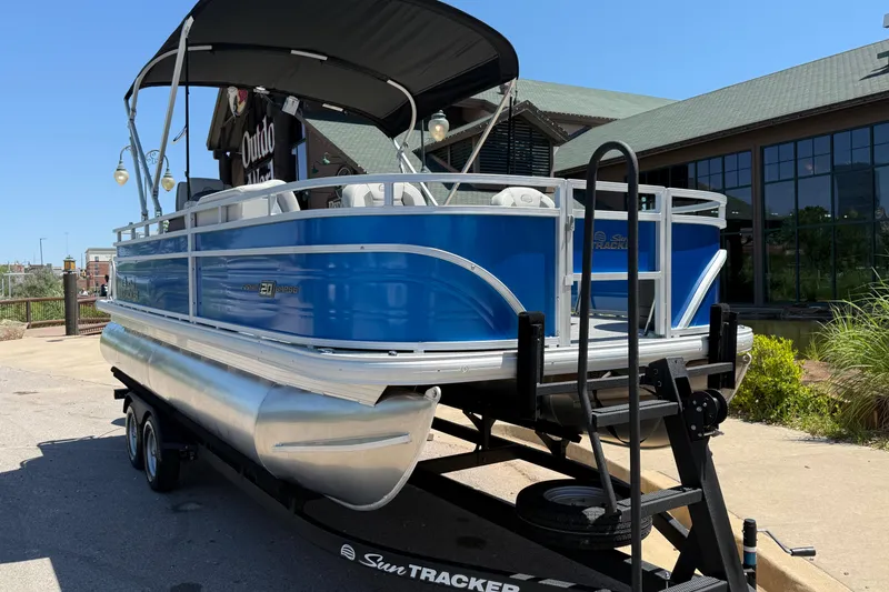 Slide: The Image of 2026 Sun Tracker Fishin' Barge 20 DLX pontoon boat on trailer, outdoor setting. - 11