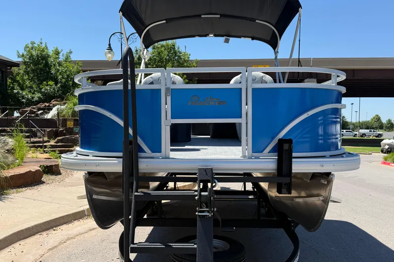 Slide: The Image of 2026 Sun Tracker Fishin' Barge 20 DLX pontoon boat on trailer, outdoors. - 2