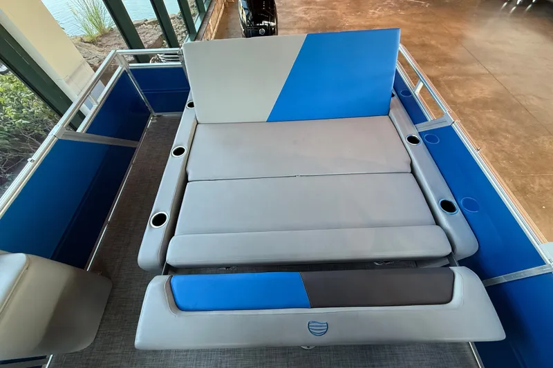 Slide: The Image of 2026 Sun Tracker Party Barge 22 RF DLX interior with blue and gray seating. - 92