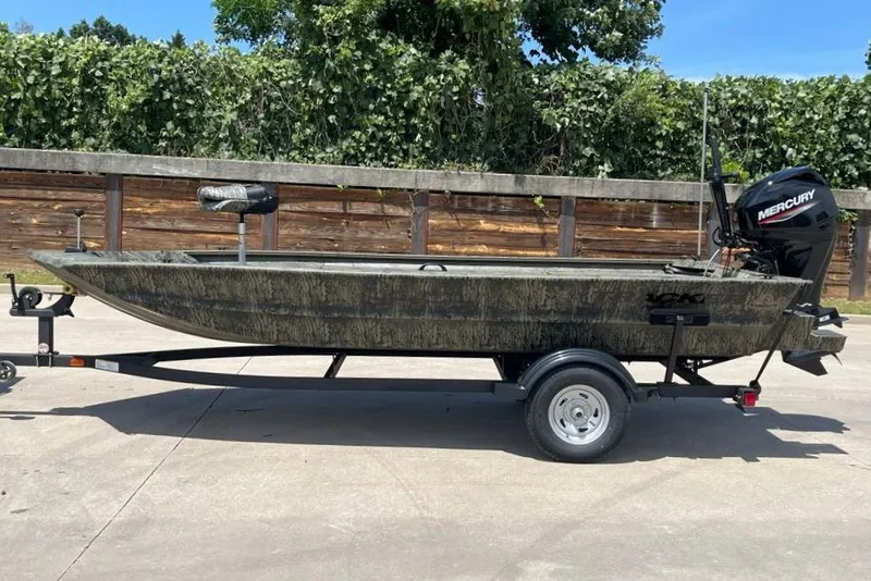 The Image of 2026 Tracker Grizzly 1654 T Sportsman boat on trailer, featuring Mercury outboard motor. - 0