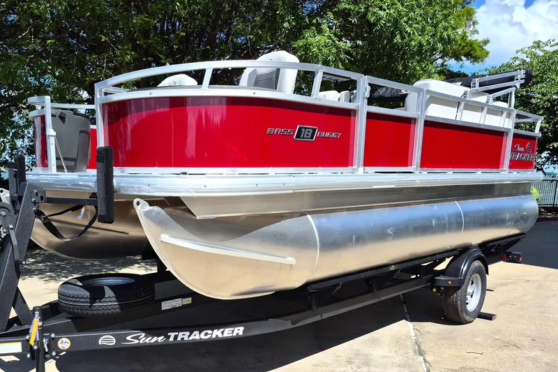Slide: The Image of 2026 Sun Tracker Bass Buggy 18 DLX pontoon boat on trailer, vibrant red exterior. - 1