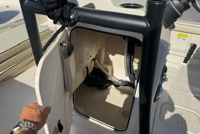 Slide: The Image of 2022 Carolina Skiff 23 LS storage compartment with open door, showcasing interior space. - 18
