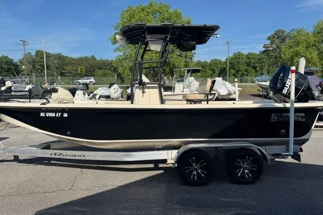 Slide: The Image of 2022 Carolina Skiff 23 LS boat on trailer, parked outdoors in a marina setting. - 2