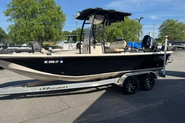 Slide: The Image of 2022 Carolina Skiff 23 LS boat on trailer, parked outdoors under clear sky. - 3
