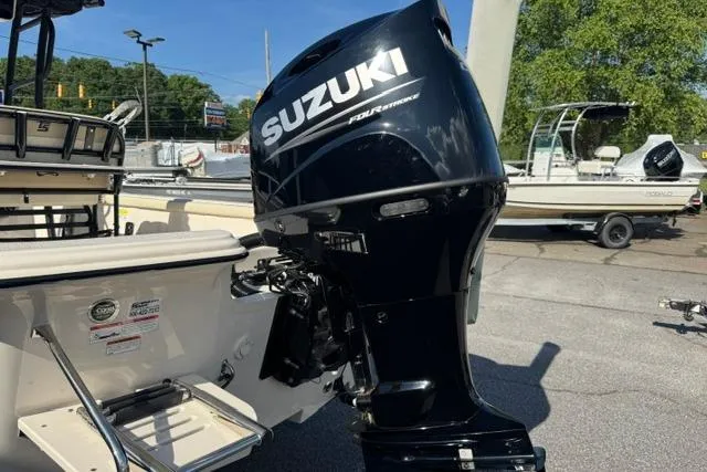 Slide: The Image of 2022 Carolina Skiff 23 LS boat with Suzuki outboard motor in a marina setting. - 5