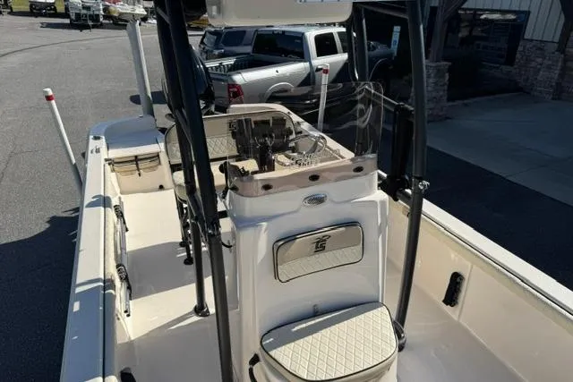 Slide: The Image of 2022 Carolina Skiff 23 LS boat interior with seating and console, parked outdoors. - 8