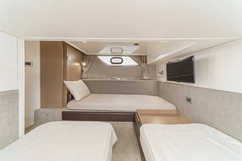 Slide: The Image of 2017 Sea Ray Sundancer 400 cabin interior with beds, TV, and modern decor. - 36