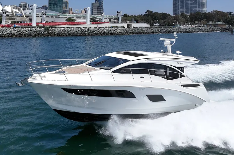 Slide: The Image of 2017 Sea Ray Sundancer 400 yacht cruising in a scenic harbor setting. - 55