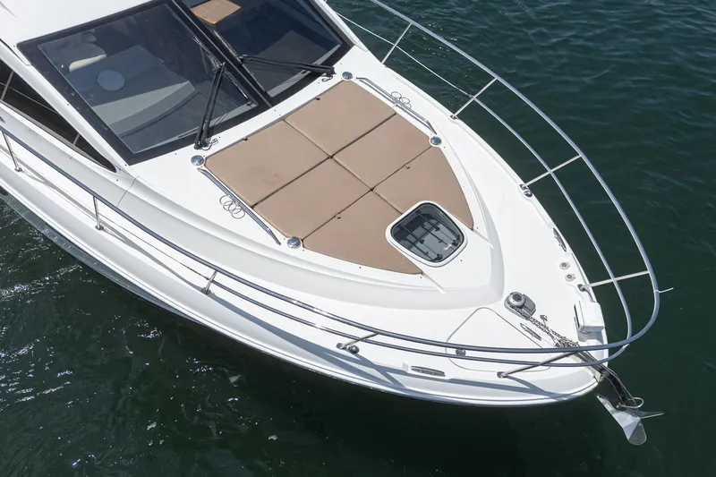 Slide: The Image of 2017 Sea Ray Sundancer 400 yacht bow view with sunpad and railing on water. - 69