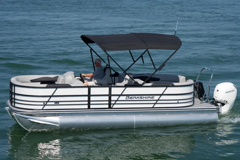 Slide: The Image of 2026 Berkshire 22 RFX LE pontoon boat cruising on water with canopy and Mercury engine. - 1