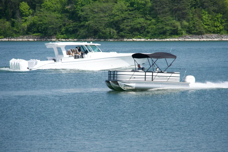 Slide: The Image of 2026 Berkshire 22 RFX LE pontoon boat cruising on a serene lake. - 19