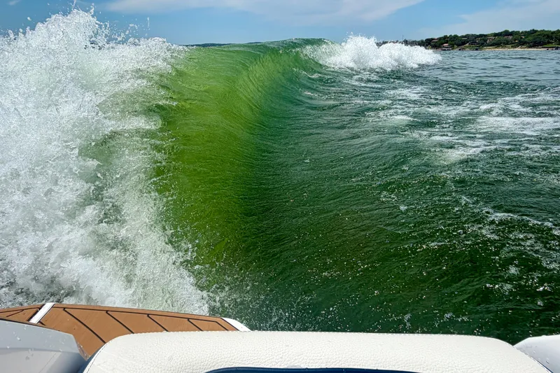 Slide: The Image of Waves created by 2022 Nautique Super Air Nautique GS24 boat on a sunny day. - 11