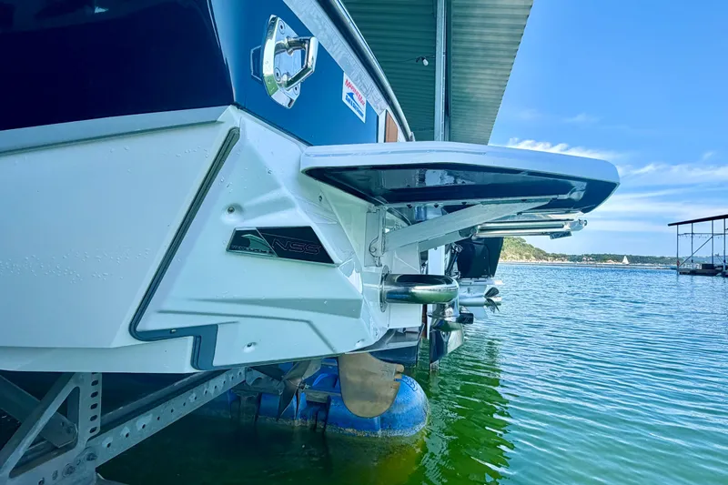Slide: The Image of 2022 Nautique Super Air Nautique GS24 docked on calm water under a clear sky. - 18