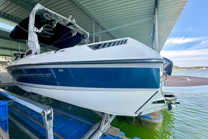 Slide: The Image of 2022 Nautique Super Air Nautique GS24 boat docked in a covered marina. - 19