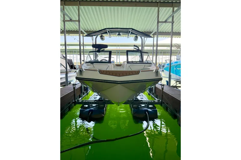 Slide: The Image of 2022 Nautique Super Air Nautique GS24 boat docked in a covered marina. - 21