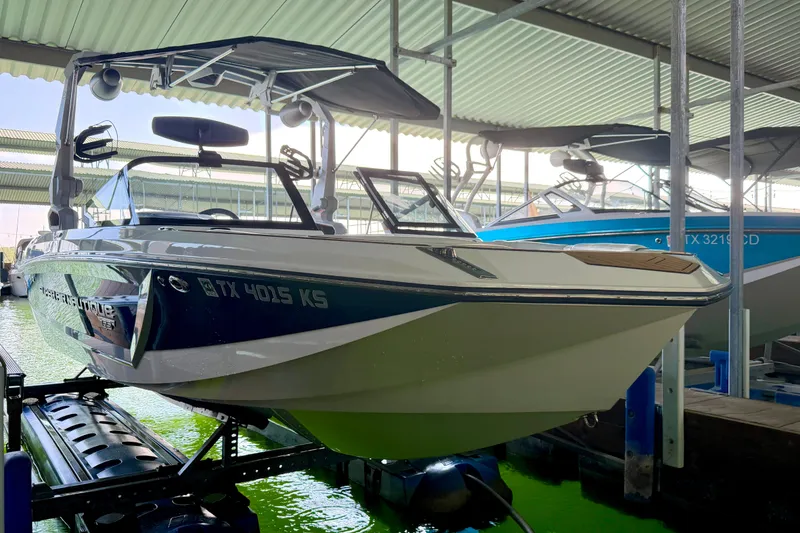 Slide: The Image of 2022 Nautique Super Air Nautique GS24 boat docked in a covered marina. - 22