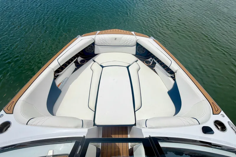 Slide: The Image of 2022 Nautique Super Air Nautique GS24 boat interior with white seating on water. - 26