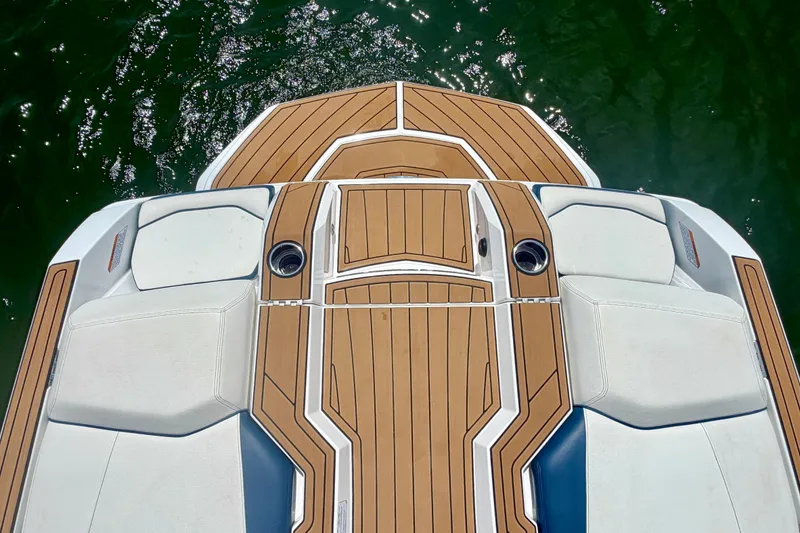 Slide: The Image of 2022 Nautique Super Air Nautique GS24 boat deck with teak finish on water. - 30