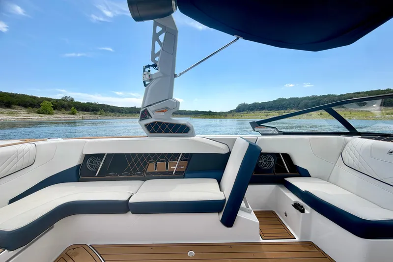 Slide: The Image of 2022 Nautique Super Air Nautique GS24 interior with luxurious seating, overlooking a serene lake. - 35