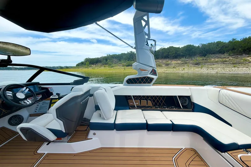 Slide: The Image of 2022 Nautique Super Air Nautique GS24 interior with luxurious seating and modern dashboard. - 36