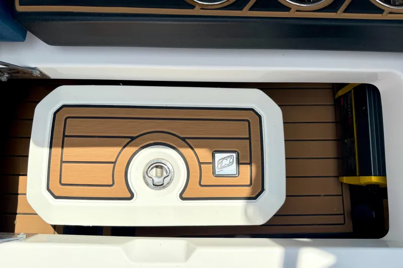 Slide: The Image of 2022 Nautique Super Air Nautique GS24 storage compartment with teak finish and secure latch. - 41