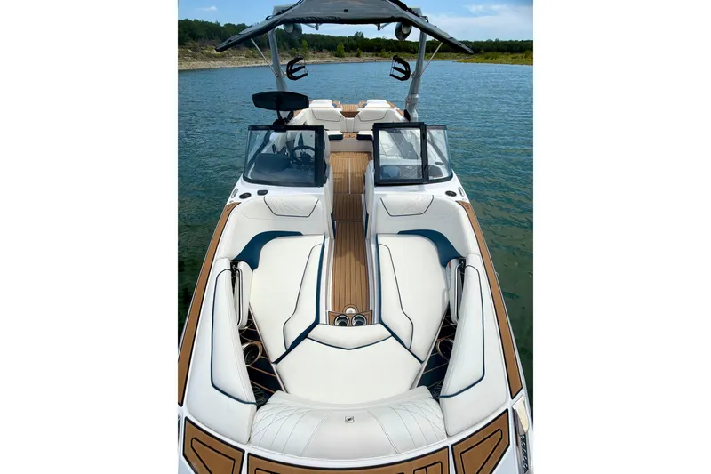 Slide: The Image of 2022 Nautique Super Air Nautique GS24 boat interior on a lake, featuring sleek seating and modern design. - 44