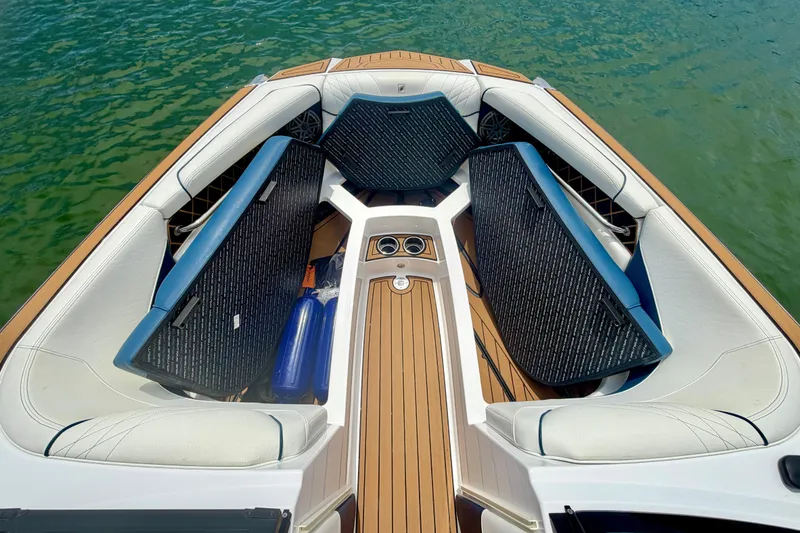 Slide: The Image of 2022 Nautique Super Air Nautique GS24 boat interior with cushioned seating and teak flooring. - 45