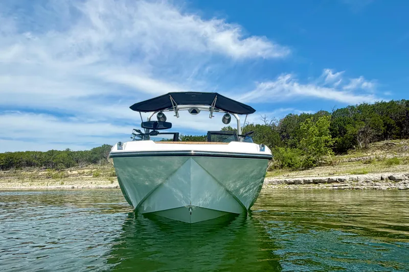 Slide: The Image of 2022 Nautique Super Air Nautique GS24 boat on calm lake with clear sky. - 9