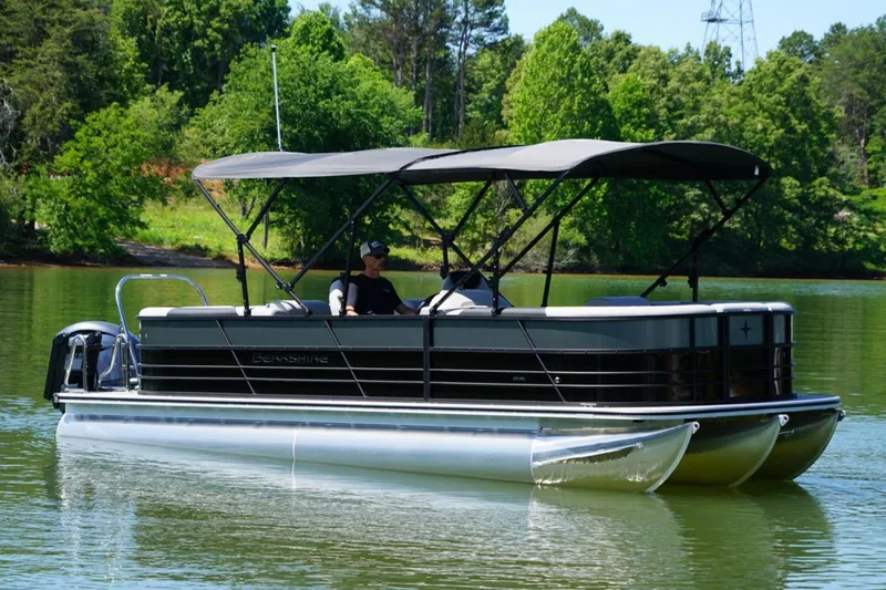 The Image of 2026 Berkshire 24 RFX LE pontoon boat cruising on a serene lake. - 0