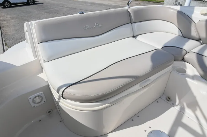 Slide: The Image of 2002 Sea Ray 240 Sundeck boat interior with cushioned seating and cup holders. - 10