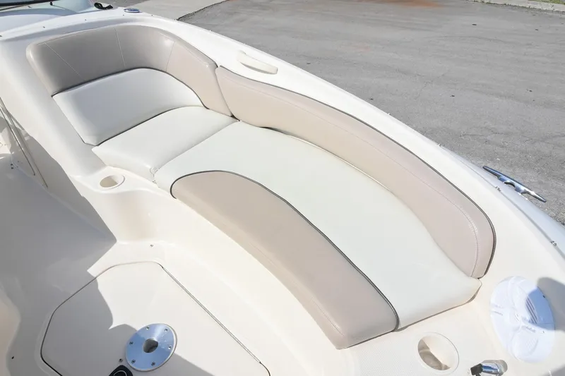 Slide: The Image of 2002 Sea Ray 240 Sundeck boat interior with cushioned seating and cup holders. - 11