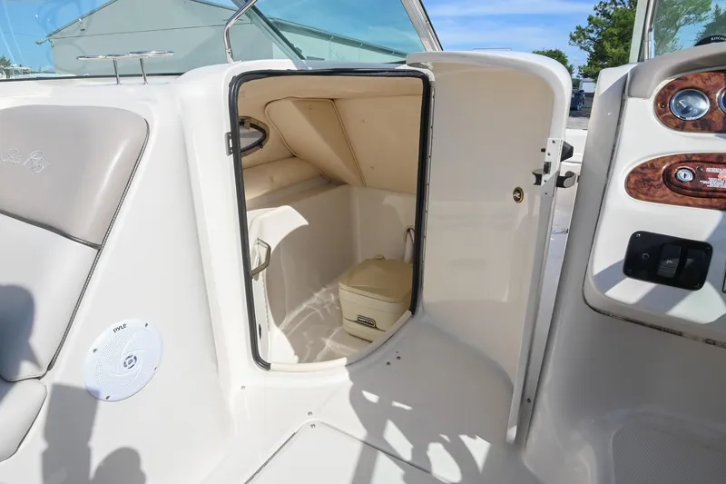 Slide: The Image of 2002 Sea Ray 240 Sundeck boat interior with open storage compartment and control panel. - 12