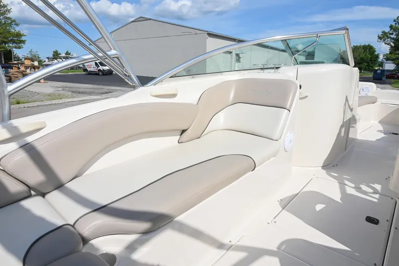 Slide: The Image of 2002 Sea Ray 240 Sundeck boat interior with beige seating and sleek design. - 14