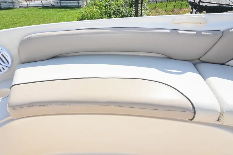 Slide: The Image of 2002 Sea Ray 240 Sundeck boat seating with beige upholstery and speaker detail. - 15