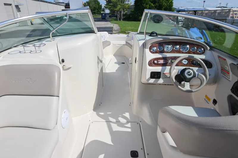 Slide: The Image of 2002 Sea Ray 240 Sundeck interior with steering wheel and dashboard, showcasing elegant design. - 17