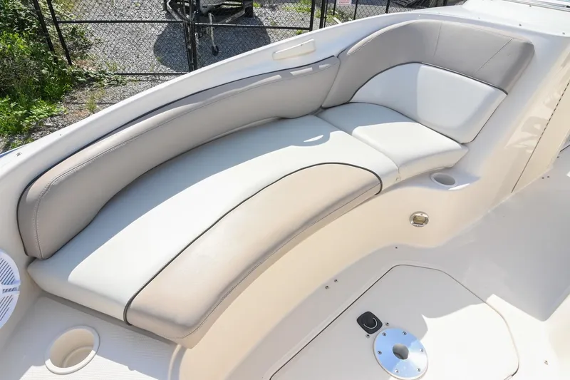 Slide: The Image of 2002 Sea Ray 240 Sundeck boat interior with cushioned seating and cup holders. - 26