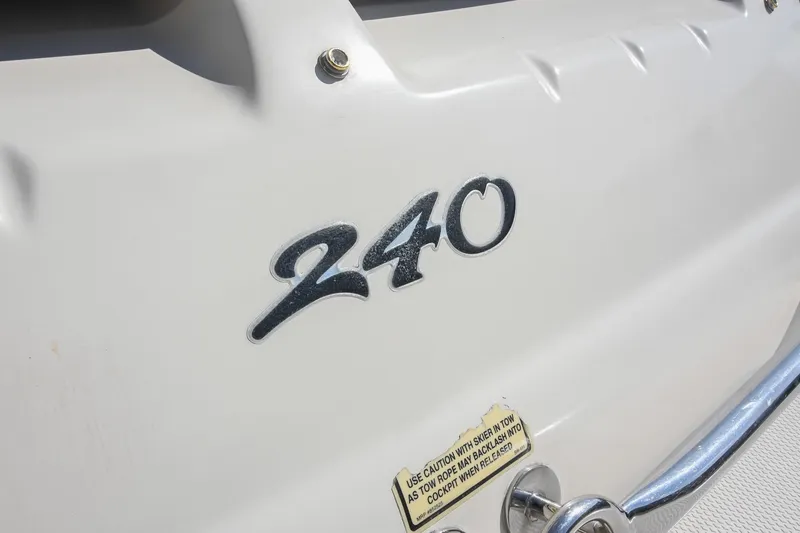 Slide: The Image of Close-up of 2002 Sea Ray 240 Sundeck boat emblem and caution label. - 32