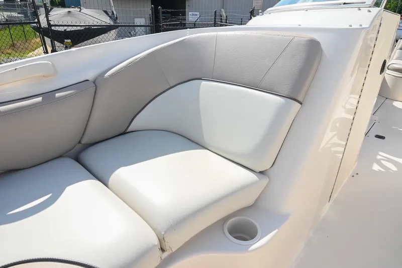 Slide: The Image of 2002 Sea Ray 240 Sundeck interior seating with white and gray upholstery. - 34