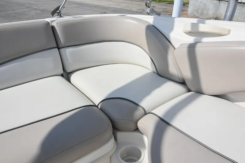 Slide: The Image of 2002 Sea Ray 240 Sundeck interior seating with beige upholstery and cup holder. - 35