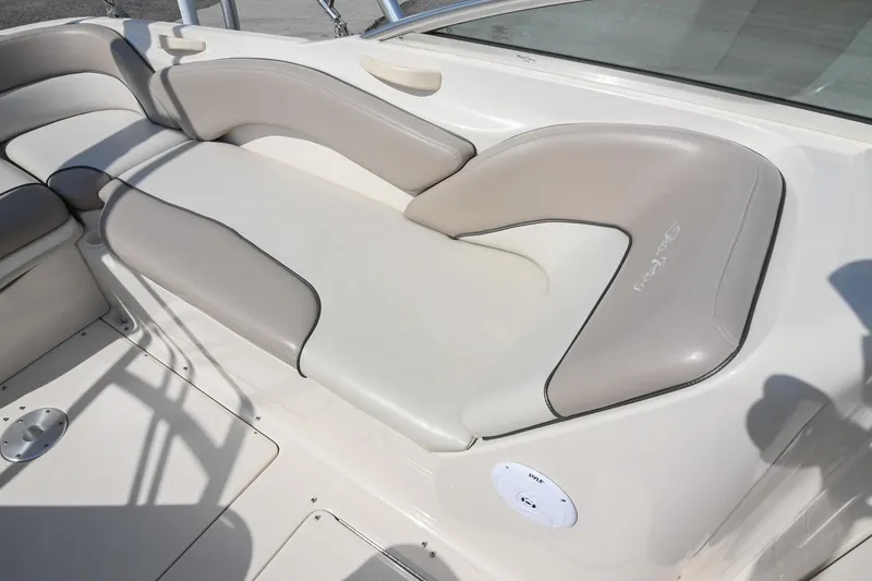 Slide: The Image of 2002 Sea Ray 240 Sundeck interior with beige cushioned seating and speaker detail. - 40