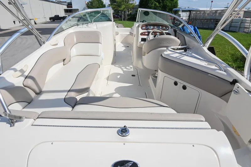 Slide: The Image of 2002 Sea Ray 240 Sundeck interior with seating and helm, showcasing spacious design. - 6