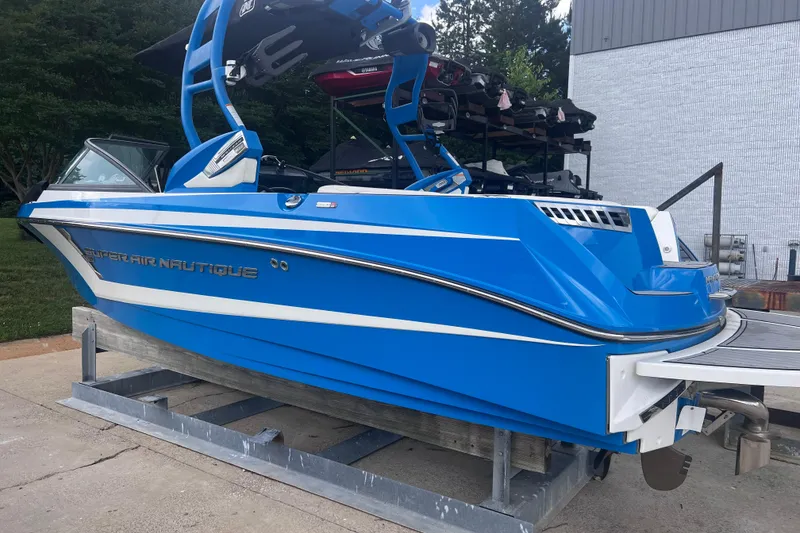 Slide: The Image of 2016 Nautique Super Air Nautique 210 boat in vibrant blue on a trailer. - 16