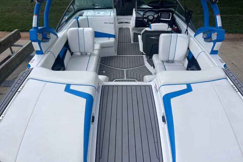 Slide: The Image of 2016 Nautique Super Air Nautique 210 interior with white and blue seating, sleek design. - 19