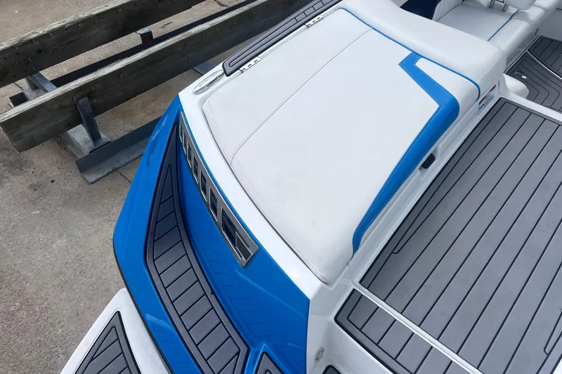 Slide: The Image of 2016 Nautique Super Air Nautique 210 boat with blue and white seating and deck. - 20