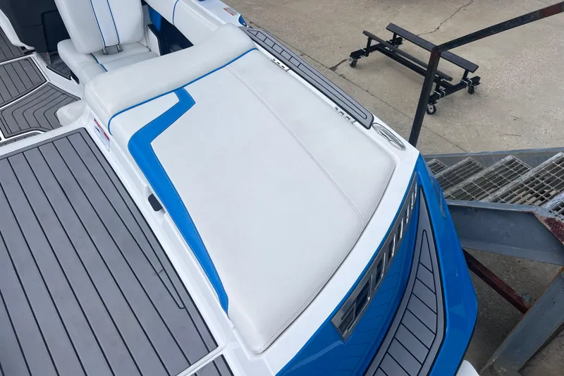 Slide: The Image of 2016 Nautique Super Air Nautique 210 boat interior with blue and white seating. - 21