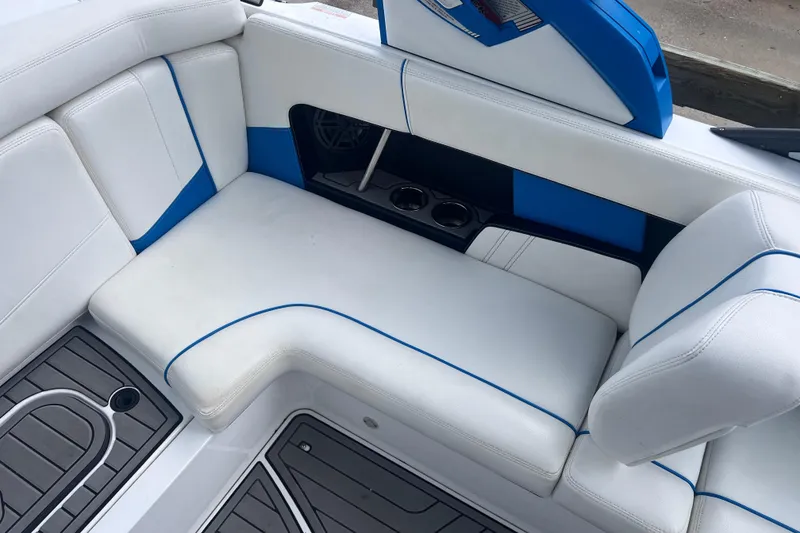 Slide: The Image of 2016 Nautique Super Air Nautique 210 interior with white and blue seating, cup holders, and speaker. - 25