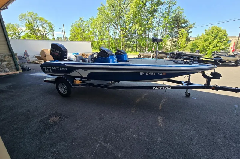 Slide: The Image of 2014 Nitro Z-7 boat on trailer, parked outdoors with trees in background. - 1