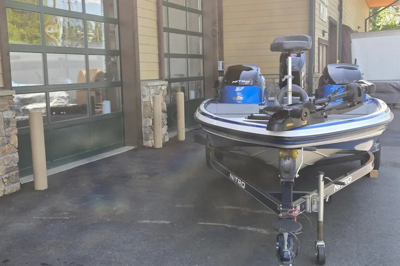 Slide: The Image of 2014 Nitro Z-7 boat parked outside a garage, featuring dual motors. - 7