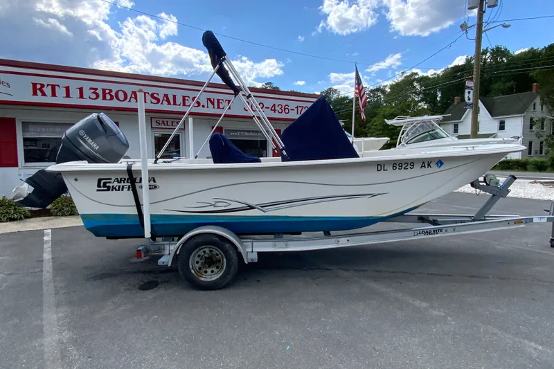 The Image of 2016 Carolina Skiff 198 DLV boat on trailer at dealership, with Yamaha outboard motor. - 1