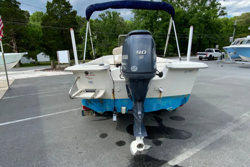 Slide: The Image of 2016 Carolina Skiff 198 DLV boat with Yamaha 90 engine, parked outdoors. - 13